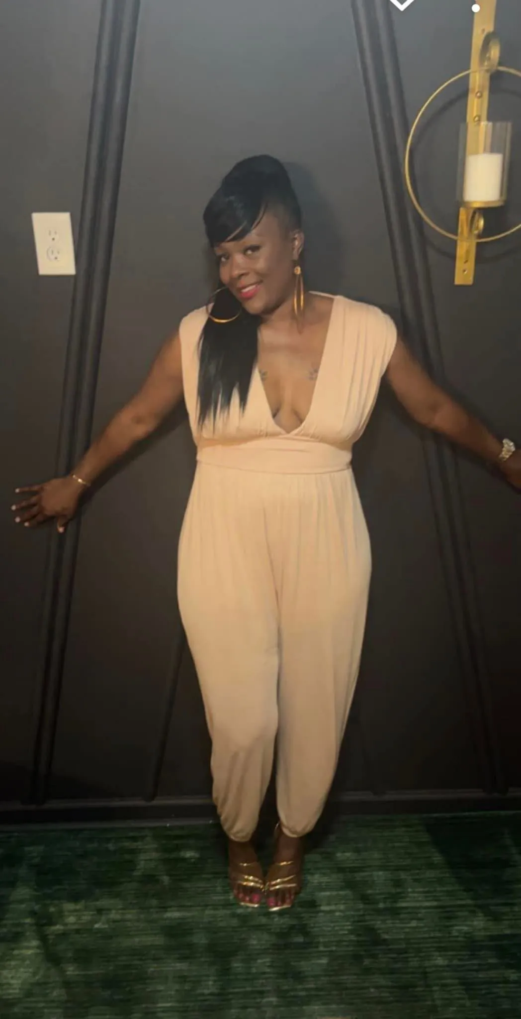 Nude jumpsuit styled with gold earrings and sandals