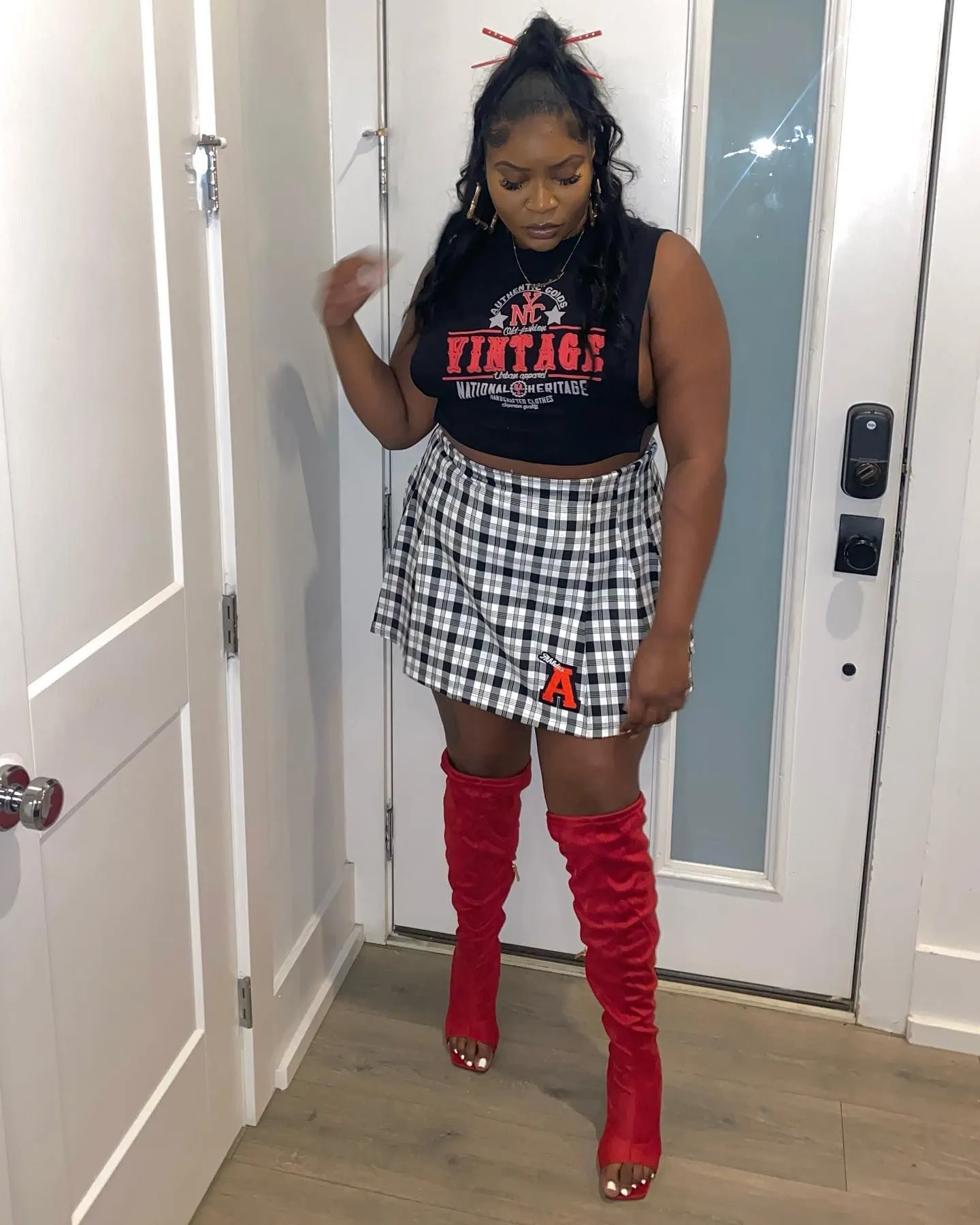 Graphic crop top, plaid skirt, and red boots